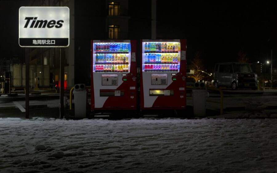 Illuminated vending machines in snowy Kameoka, Japan at night.