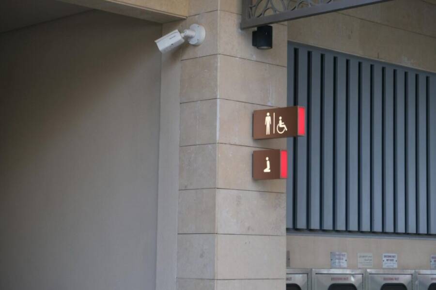 Signage at Dubai Metro station showing restroom and information symbols.