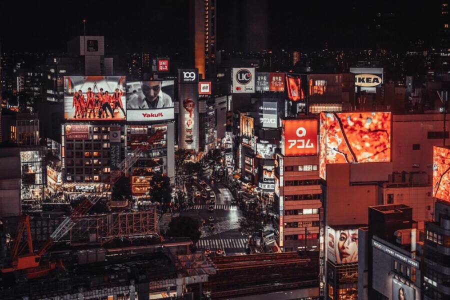 Vibrant night scene of Shibuya, Tokyo with illuminated billboards and busy streets.