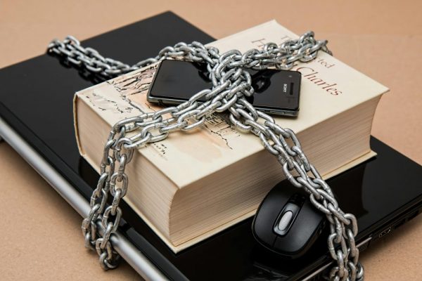 手機找不到裝置?定位與遺失模式完整教學(iPhone與Android,今年最新) Chain-locked book, phone, and laptop symbolizing digital and intellectual security