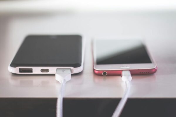 Two smartphones charging side by side on a desk. Modern and technological setting.