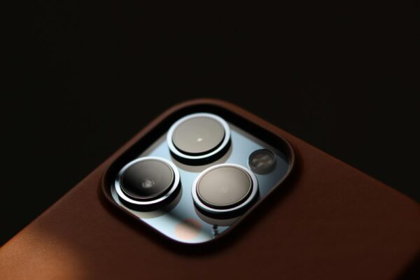 iPhone 16 最佳配件推薦:保護殼、玻璃貼、充電器與 MagSafe 全面指南 Detailed close-up of modern smartphone camera lenses in a leather case.