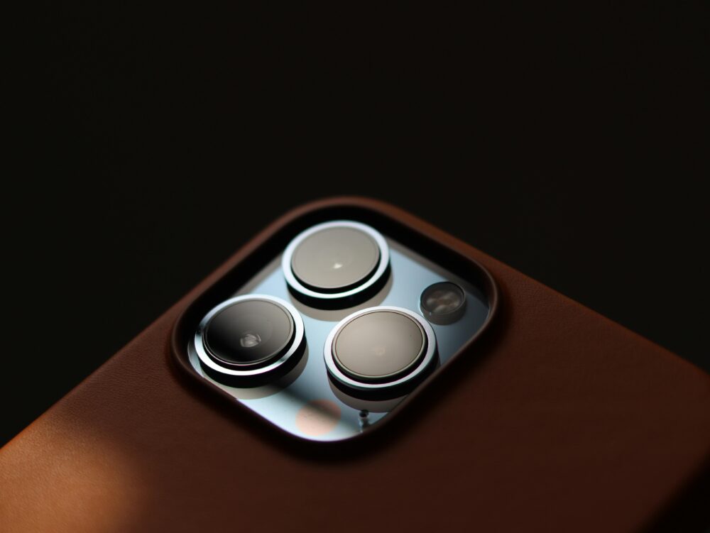 Detailed close-up of modern smartphone camera lenses in a leather case.