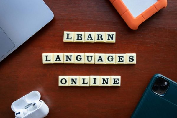 手機鍵盤記憶錯字怎麼辦:清除辭典與正確訓練指南 Flat lay of language learning tools with devices and text blocks on desk.