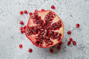 A detailed image of a pomegranate half with seeds on a marble background, showcasing vibrant red hues.