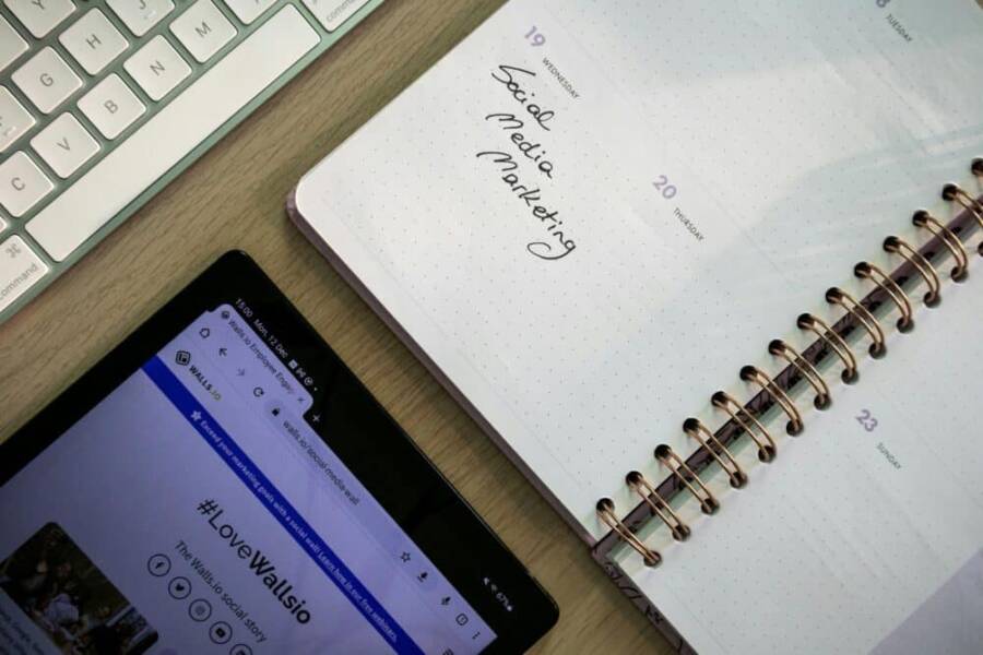 壁紙上的“social media marketing”字樣與手機社交媒體內容相呼應，展示數位行銷策略與社交媒體運營，反映現代行銷的重要工具。.