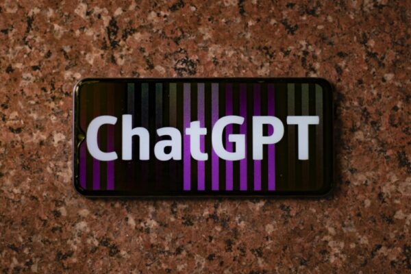 Smartphone displaying ChatGPT on an abstract colorful background, top view.