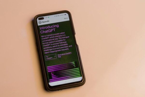 AI 生產力工具應用指南:Notion AI、ChatGPT、Copilot 實戰教學 Smartphone screen showing ChatGPT introduction by OpenAI, showcasing AI technology.