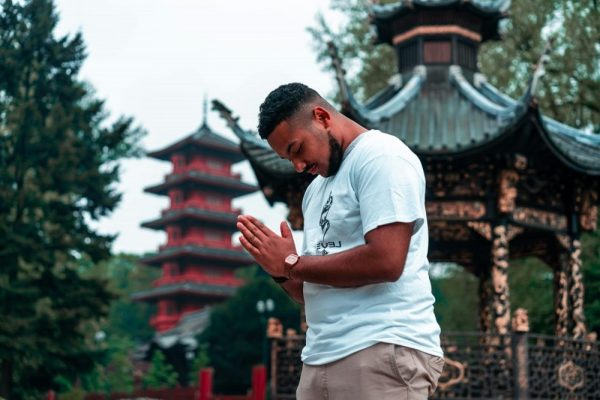A serene moment of meditation in a traditional Asian garden with pagodas.