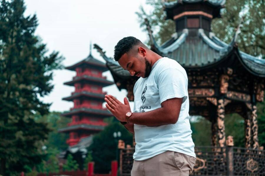 A serene moment of meditation in a traditional Asian garden with pagodas.