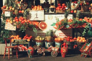 Colorful market stall in Catania, Sicily showcasing fresh fruits and local artisan crafts.