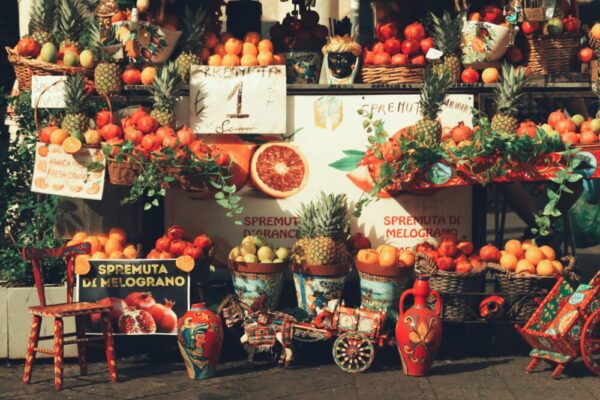 Colorful market stall in Catania, Sicily showcasing fresh fruits and local artisan crafts.