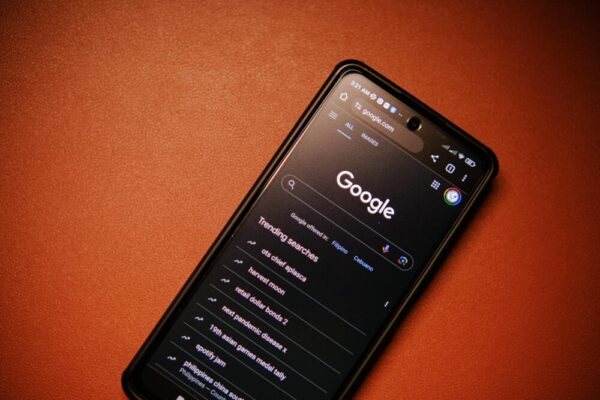 如何運用 Google Trends 找到爆紅主題, 實戰教學與 SEO 選題指南 A smartphone displaying Google Search trends on a table at night.