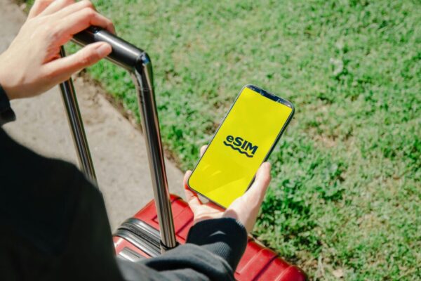 香港轉機短時上網方案與設定全攻略:機場WiFi、預付SIM 與 eSIM 的實務指南與 APN 設定要點 image of device with eSIM setup in hand