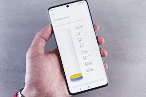 Hand holding smartphone displaying storage space usage with a clean interface.