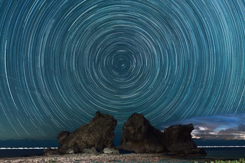 Stunning night sky star trails over a rock formation on Lanyu Island, Taiwan.