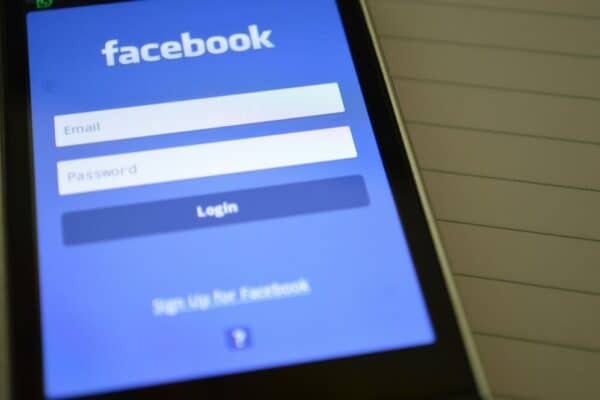 Facebook 粉專還有用嗎?現況分析與經營策略指南(含台灣數據) Facebook登入畫面,手機顯示Facebook登入頁面,顯示電子郵件和密碼輸入框,強調社群媒體、數位行銷和線上平台連結。.