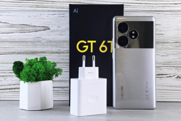 Realme 快充與電池養護(快充效率、電池寿命、充電保护):提升充電速度與延長手機壽命的實用指南 Close-up of a Realme smartphone with charger and potted plant on a wooden surface
