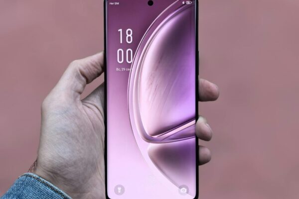 vivo V30 評測:自拍、螢幕與輕薄手感全面剖析(自拍、屏幕、轻薄手感) A person holding a sleek, modern smartphone with a purple screen against a plain background