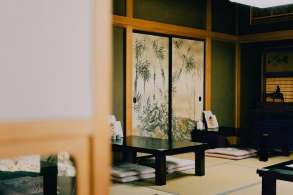 Serene view of a traditional Japanese tatami room with painted sliding doors and low tables.