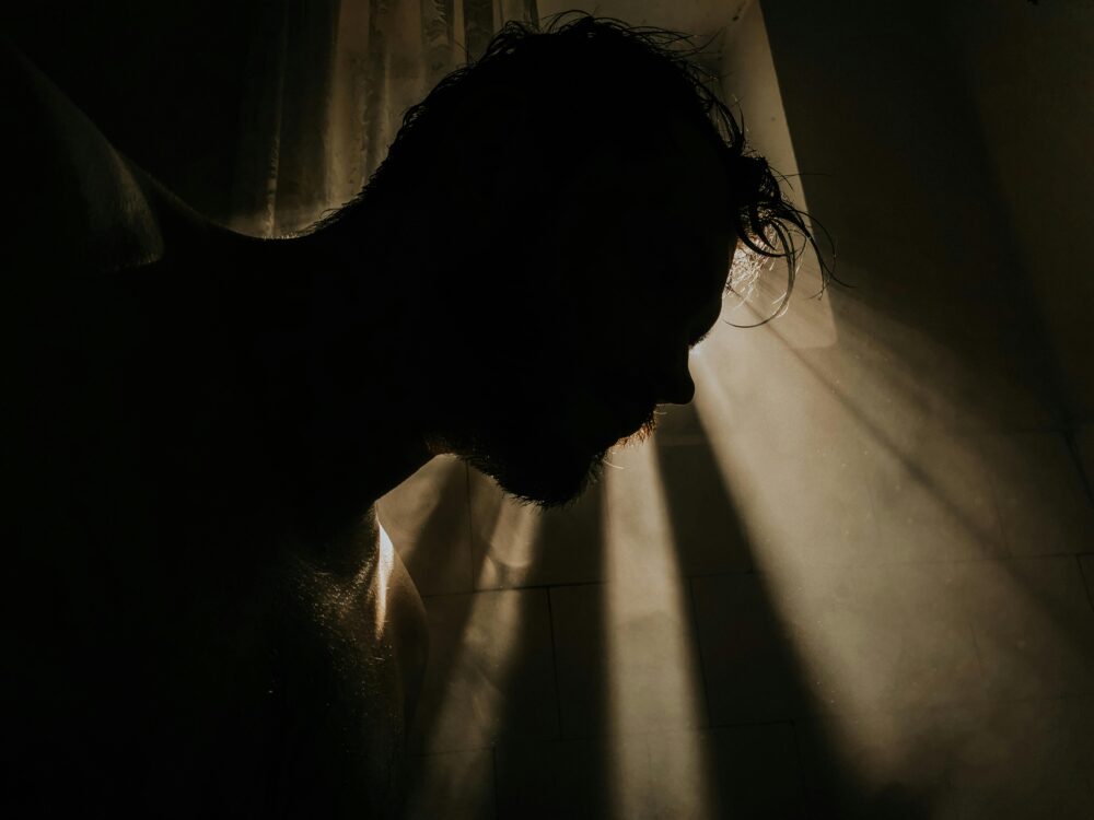 A mysterious silhouette of a man with dramatic lighting and shadows creating an artistic effect.