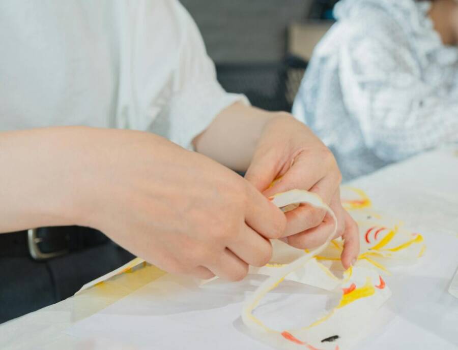 Close-up of hands crafting paper art in a Tokyo classroom, showcasing artistic creativity.