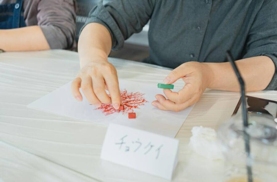 Hands creating pastel artwork during an art class in Shinjuku, Tokyo, Japan.