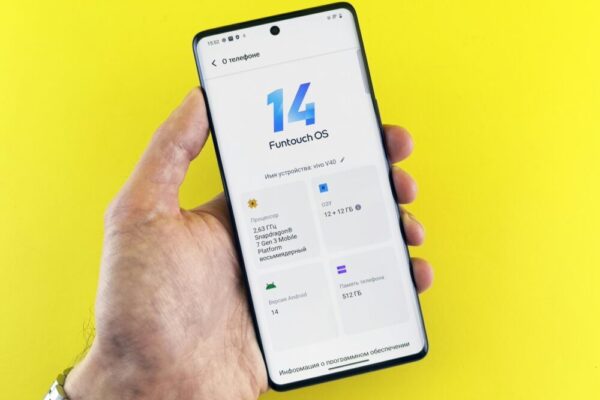 vivo 手機台港星馬價格比較與購買指南(vivo手机台港星马价格比较与购买要点) Close-up of a hand holding a smartphone displaying Funtouch OS 14 on a vibrant yellow background.