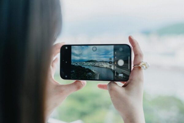 A person photographing the beautiful coastline of Nishiizu, Shizuoka, Japan, emphasizing travel and exploration.