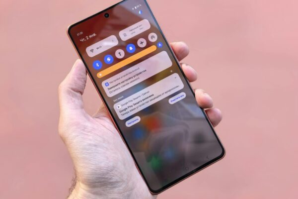 Close-up view of a person holding a smartphone showing notifications and icons on screen