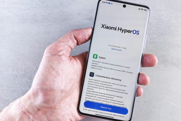 小米手機台港星馬價格比較與購買指南:通路保固全攻略(小米手机 台港星马价格) Close-up of a hand holding a Xiaomi smartphone with HyperOS interface, showcasing comprehensive refactoring and system update details.