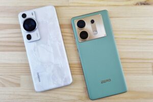 Close-up of two modern smartphones on a wooden table, contrasting designs and colors.