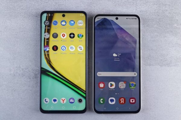 Top-down view of two modern smartphones with home screens displayed on a textured surface.