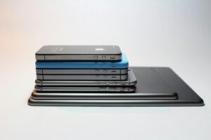 2025年最值得入手的智慧型手機推薦:AI相機、折疊與續航全指南(含各價位清單) Stacked modern smartphones and tablets showcasing sleek design. Perfect tech background.