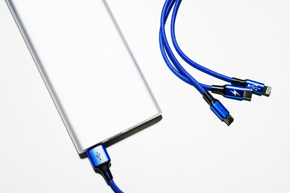Minimalist image of a power bank with blue USB charging cables on a white background