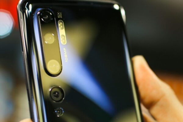 Detailed close-up of a smartphone camera lens reflecting light, showcasing advanced technology.