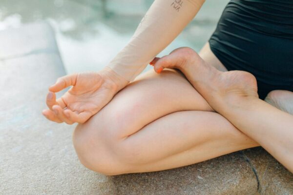 Close-up of a person meditating outdoors, focusing on a serene yoga pose for relaxation.