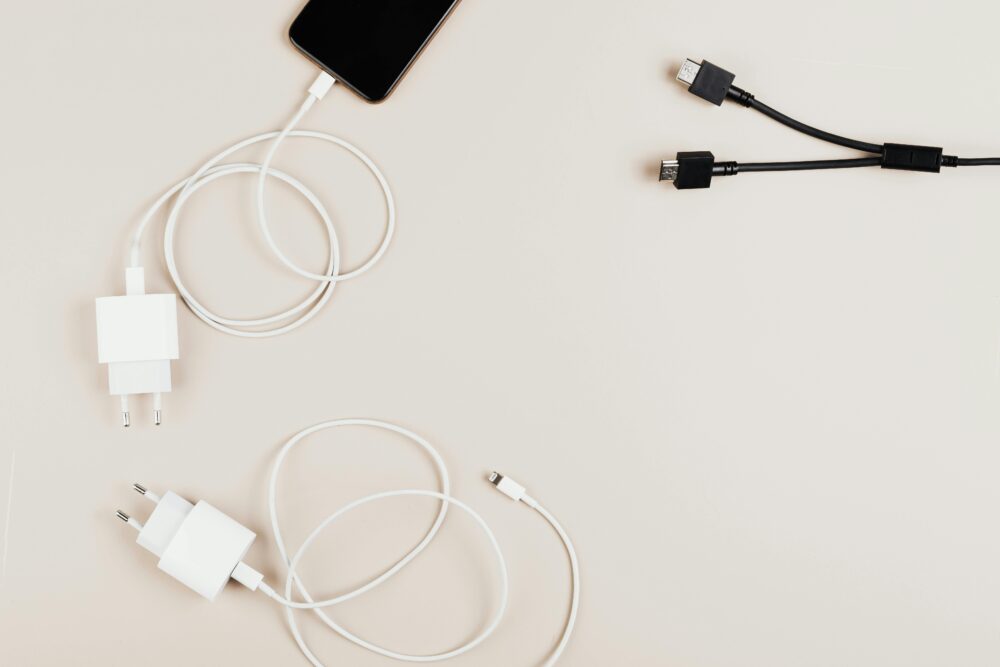 Flat lay of mobile devices with chargers and cables on a neutral background
