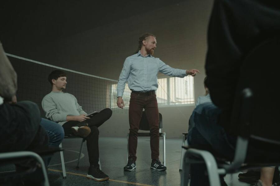 A group therapy session indoors with diverse adults engaging in discussion and support.