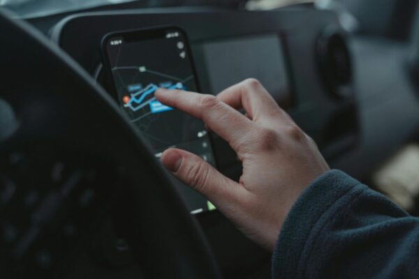 One UI 實用技巧大全:側邊欄、手勢、分屏多工(One UI 实用技巧:侧边栏、手势、分屏) Hand interacting with GPS navigation on a smartphone mounted in a car interior.