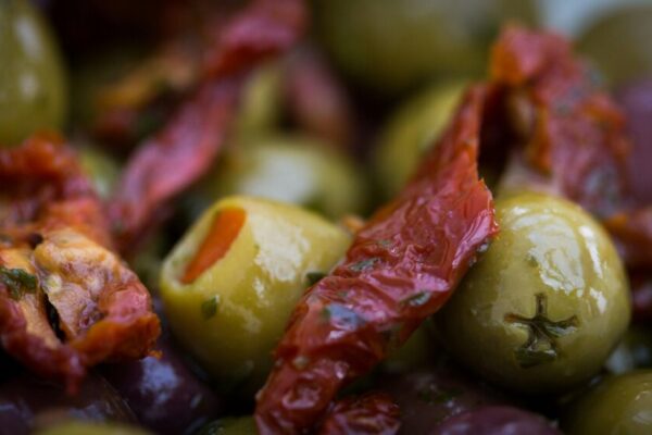 Vibrant marinated olives and sun-dried tomatoes in a savory setting.