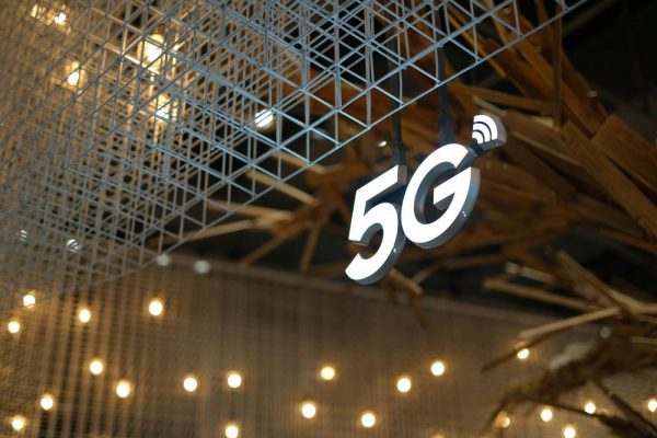 手機5G變慢掉到4G怎麼辦?頻段與營運商設定排查指南 Illuminated 5G sign with modern geometric ceiling and warm lighting