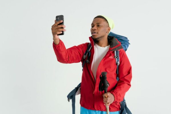 Man in hiking gear checking his smartphone for navigation indoors