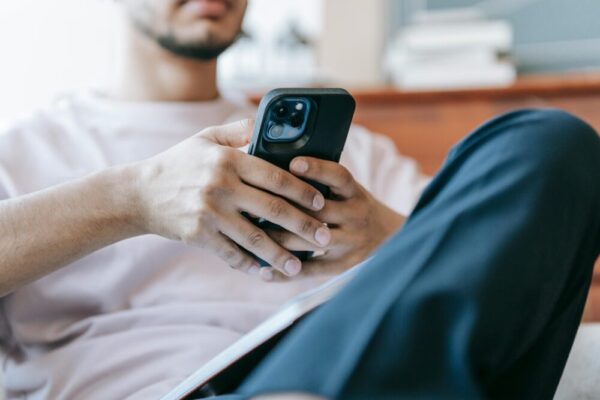手機 App 內瀏覽 vs 外部瀏覽器切換:用戶體驗與設計實務要點 Crop bearded male in casual clothes browsing mobile phone and sitting in light living room