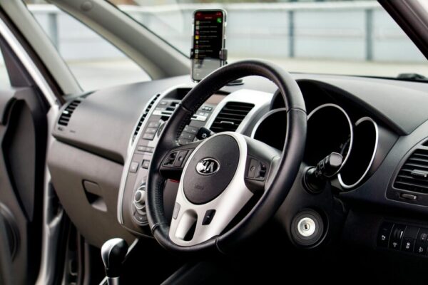 Close-up of a modern car interior featuring a dashboard, steering wheel, and smartphone mount