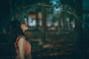 A captivating portrait of a woman in a serene forest setting, embracing nature