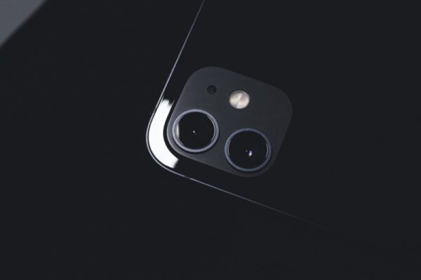 Macro shot of a smartphone camera lens on a glossy surface, emphasizing modern technology.