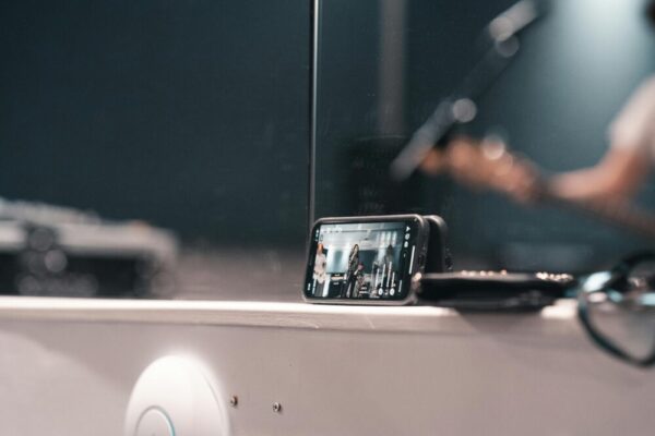 A smartphone recording a live band performance at an indoor event.