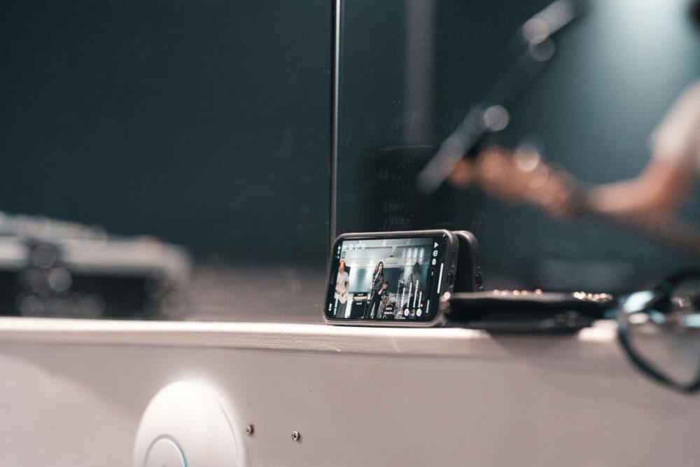 A smartphone recording a live band performance at an indoor event.