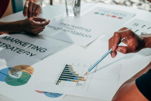 Team working on marketing strategy using data charts and papers in an office meeting.